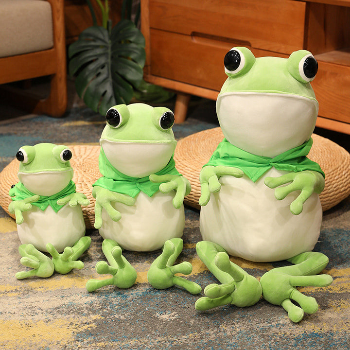 Une adorable peluche grenouille verte aux grands yeux noirs et à la cape verte, posant avec ses pattes avant tendues